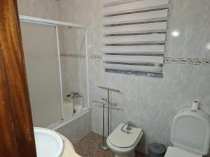 Un baño blanco con inodoro y lavabo. en Constança House, en Corroios 9 fotos más