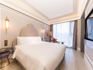 Ένα ή περισσότερα κρεβάτια σε δωμάτιο στο Mercure Xi'an Dayan Pagoda +84 φωτογραφίες