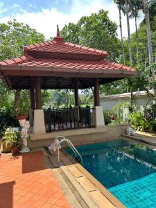 a swimming pool with a gazebo next to a swimming pool at 4 bedroom Villa with Private pool at Laguna in Angsana in Ban Thalat Choeng Thale