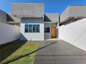 una casa bianca con una porta e un cortile di Casa 2 quartos prox centro, Argent, Marco 3 front a Foz do Iguaçu