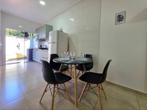 una cucina con tavolo con sedie e frigorifero di Casa 2 quartos prox centro, Argent, Marco 3 front a Foz do Iguaçu
