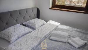 a bed with two pillows on it next to a window at Apartman Nela 2 Jahorina in Jahorina