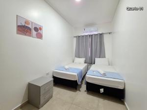 una piccola stanza con due letti e una finestra di Casa 2 quartos prox centro, Argent, Marco 3 front a Foz do Iguaçu