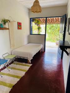 une chambre avec un lit, une table et une fenêtre dans l'établissement Casinha colibri, à Conceição da Ibitipoca 27 autres photos