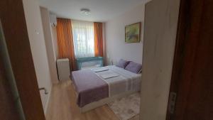 a small bedroom with a bed and a window at White grapes apartment in Petrich