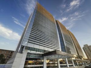 ein großes Gebäude mit einem Schild an der Vorderseite in der Unterkunft Mercure Beijing Zhongguancun in Peking