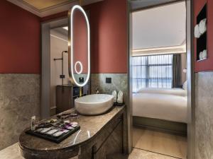 a bathroom with a sink and a bed at Mercure Beijing Zhongguancun in Beijing