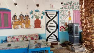 a living room with a couch and paintings on the wall at Al Salam Camp in Luxor