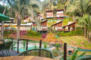 a resort with a pool and a resort with palm trees at Azzuro Hotel in Guaramiranga