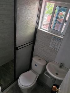 a bathroom with a toilet and a sink and a window at Casa Acaritama 4 in Melgar