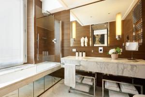 a bathroom with a tub and a sink and a shower at Nobu Hotel Roma in Rome +42 photos
