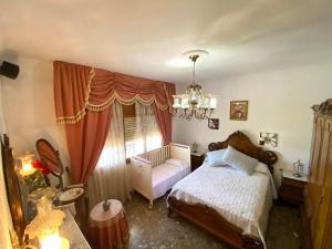 a bedroom with a bed and a chair and a chandelier at Casa-Villa en Lorca relax vistas y piscina privada in Lorca +52 photos