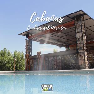 una piscina frente a un edificio con un cartel en Cabañas Cumbre, en La Porteña