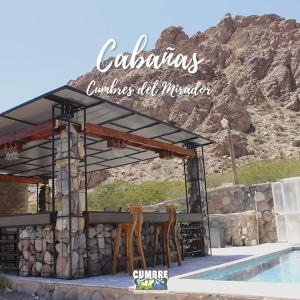 Un pabellón con dos sillas junto a una piscina. en Cabañas Cumbre, en La Porteña