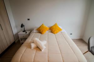 a large bed in a room with yellow pillows at Apartamento en Valdivia, Tv, Wifi, Lavandería, Estacionamiento in Valdivia