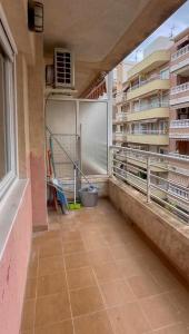 un balcone vuoto di un edificio con vista su un edificio di Chambre privée a Torrevieja