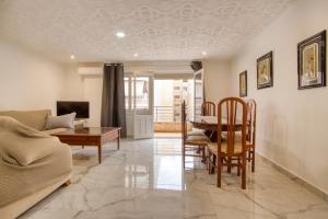 un soggiorno con un divano e un tavolo di Chambre privée a Torrevieja