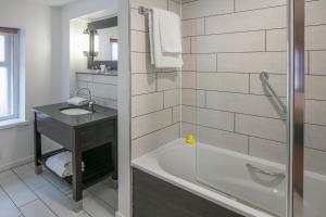 a bathroom with a tub and a sink at Fenwick Street Hotel by EPIC in Liverpool