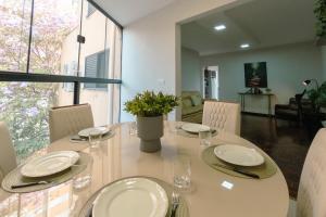 a dining room with a table with plates and glasses at Conforto e Localização TOP - MJ41 in Maringá