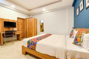 a bedroom with a bed and a desk and a television at The Rush Imperial in Indore