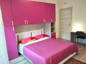 a bedroom with a pink bed and pink cabinets at Casa di Lucio in Lodi