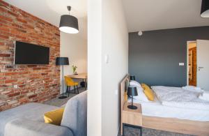a bedroom with a bed and a brick wall at ApartHOTEL Gostyń in Gostyń