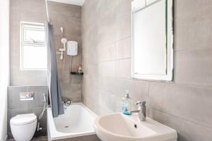 a bathroom with a sink and a shower and a toilet at Burley Guest House in Headingley