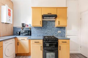 a kitchen with wooden cabinets and a stove top oven at Burley Guest House in Headingley +7 photos