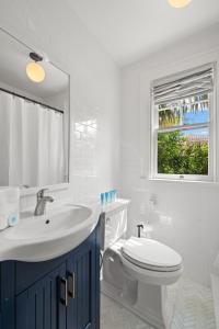 Un baño con lavabo, inodoro y ventana. en The Adaline - Entire Complex In Hyde Park, en Tampa