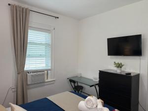 イングルウッドにあるCozy Private bedrooms Kitchen Wifiのベッドとテレビと窓のある寝室