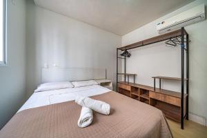a bedroom with a bed with two white towels on it at Boulevard 110-B - Excelente apartamento em condomínio de luxo no centro de Bombinhas - Piscina - Jacuzzi - Academia - Portaria 24h. in Bombinhas +21 photos