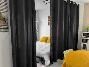 a bedroom with black curtains and a bed at Une pause à Magny appartement de 51 m2 proche Beaune et Dijon NETFLIX gratuit in Magny-lès-Villers