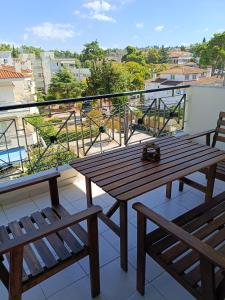 a wooden table and two benches on a balcony at Like at home in Perea