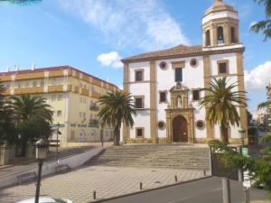 a building with a clock tower and palm trees at Hotel Royal in Ronda