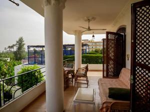 卢克索Villa Quiet Place的阳台的门廊配有沙发和桌子