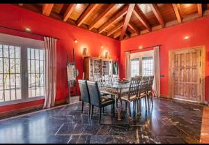a dining room with red walls and a table and chairs at Finca el descanso manchego in Fuente de Pedro Naharro