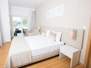 a white bedroom with a large white bed with white pillows at Tavira Monte in Tavira