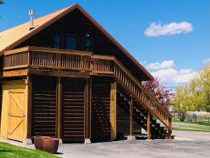 a large wooden cabin with a large wooden staircase at 2 Bedroom Loft on Horse, Goat, Donkey and Cow Farm in Bozeman