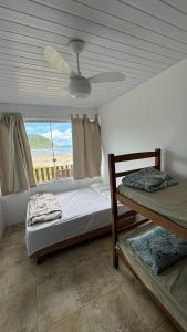 a bedroom with a bed and a ceiling fan at Pousada do Luz in Imbituba