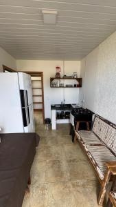 a kitchen with a refrigerator and a table and benches at Pousada do Luz in Imbituba