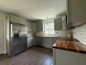 a kitchen with a stainless steel refrigerator and wooden floors at Juanitas Garden Cottage in Jonesville