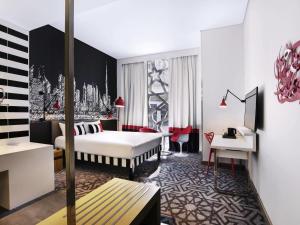 a hotel room with a bed and a desk at ibis Styles Dubai Airport Hotel in Dubai +33 photos