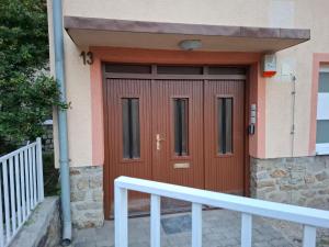 a wooden door of a house with a white rail at Soproniutas EDINApartman in Sopron