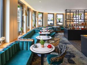a row of tables and chairs in a restaurant at Mercure Luxembourg Off Kirchberg in Luxembourg