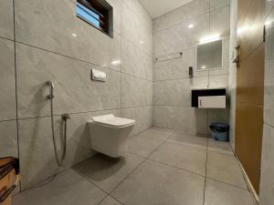 a bathroom with a toilet and a shower at Le Eden Premium Wayanad Pool Resort in Sultan Bathery +124 photos