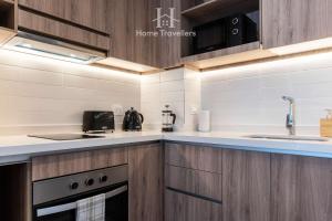 a kitchen with wooden cabinets and a sink at HT Depto en Las Condes con esta in Santiago