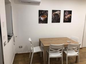une salle à manger avec une table en bois et des chaises blanches dans l'établissement La Maison de Claude, à Palerme 3 autres photos