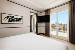 a bedroom with a bed and a flat screen tv at Nobu Hotel Roma in Rome