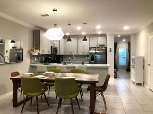 a kitchen with a wooden table and green chairs at NEW Home 3 Bedrooms Water View Disney Universal in Kissimmee