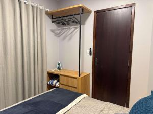 a bedroom with a bed and a wooden door at Studio Unimorada Near Lake Shopping and Market in Toledo